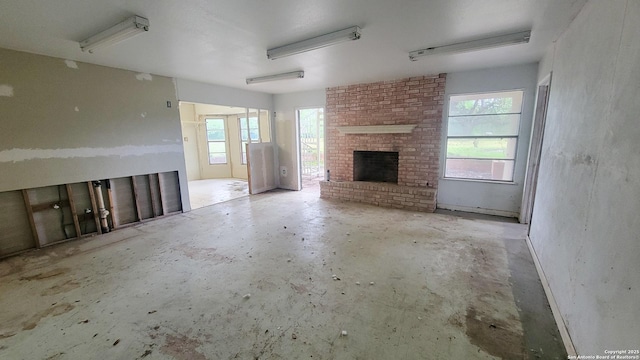 7 Glen Cove Dr, Seguin, TX 78155 - unfurnished living room with unfinished concrete flooring and a fireplace