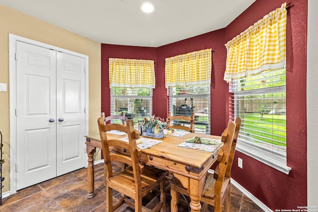 dining room featuring stone finish floors and baseboards