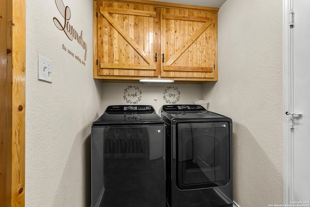 washroom with cabinet space, independent washer and dryer, and a textured wall