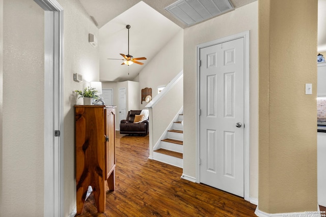 entrance foyer with ceiling fan, dark wood-style flooring, vaulted ceiling, stairway, and a textured wall