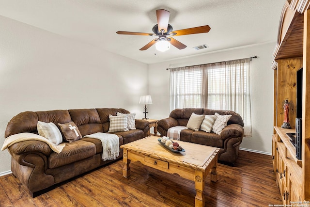 living area with a ceiling fan, dark wood-type flooring, and baseboards