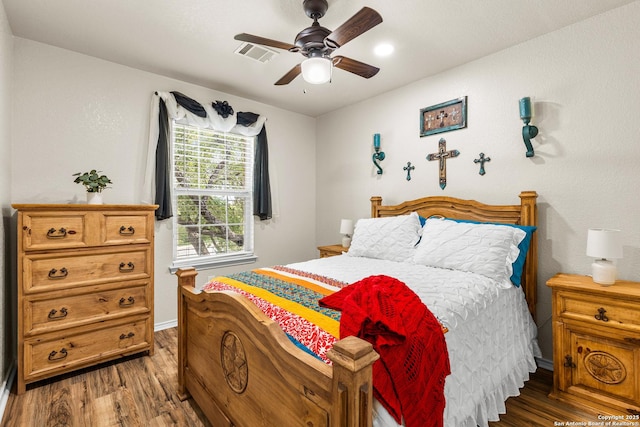 bedroom featuring wood finished floors, baseboards, and a ceiling fan