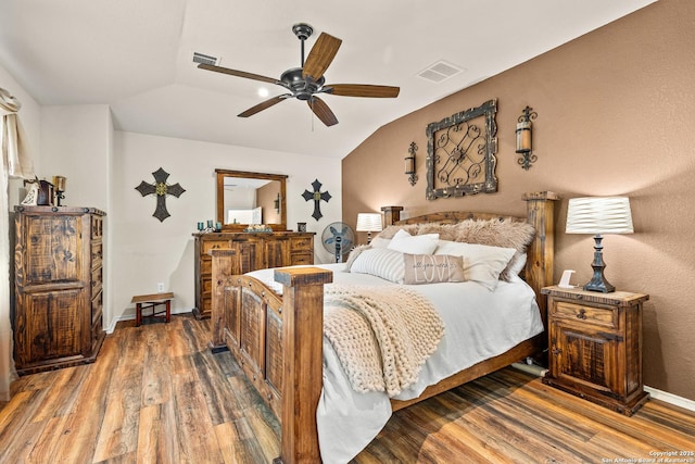 bedroom featuring wood finished floors, vaulted ceiling, a ceiling fan, and baseboards