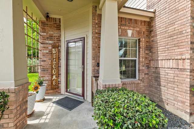 property entrance featuring brick siding and covered porch