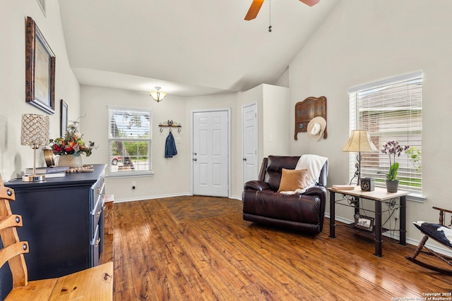 living area with dark wood-style flooring, ceiling fan, baseboards, and lofted ceiling
