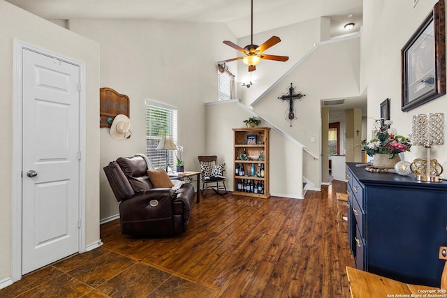 living area with stairs, high vaulted ceiling, ceiling fan, baseboards, and dark wood finished floors