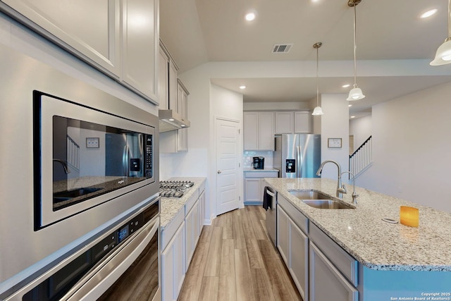 10259 Juniper Oaks, Boerne, TX 78006 - kitchen with appliances with stainless steel finishes, a sink, light wood finished floors, a center island with sink, and hanging light fixtures