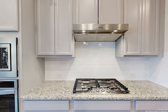 10259 Juniper Oaks, Boerne, TX 78006 - kitchen with stainless steel appliances, under cabinet range hood, backsplash, and light stone countertops