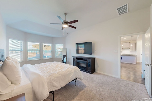 10259 Juniper Oaks, Boerne, TX 78006 - bedroom featuring light carpet, baseboards, a fireplace, a ceiling fan, and vaulted ceiling