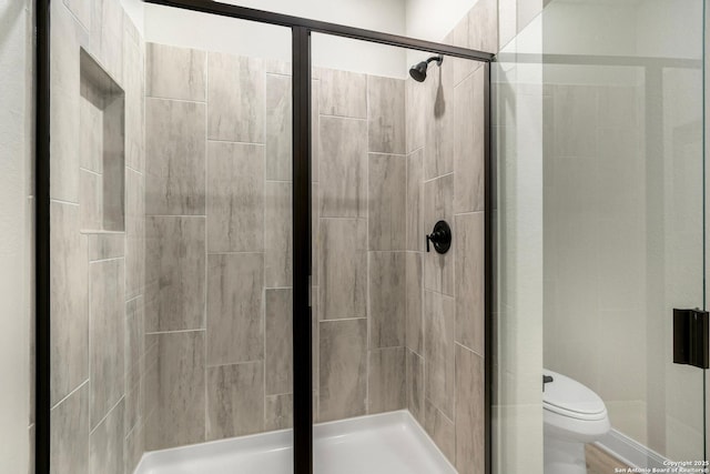 full bathroom featuring a stall shower and toilet