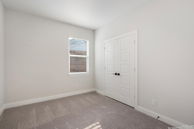 spare room featuring carpet floors and baseboards