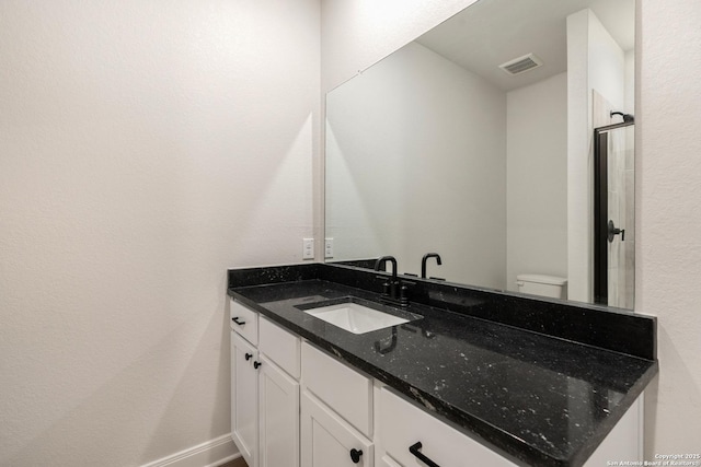 bathroom with vanity, toilet, and baseboards