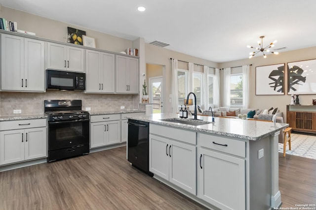 612 Wipper, New Braunfels, TX 78130 - kitchen featuring black appliances, a sink, dark wood-style flooring, backsplash, and a chandelier