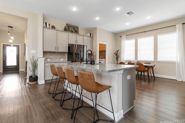 612 Wipper, New Braunfels, TX 78130 - kitchen with stainless steel fridge with ice dispenser, a kitchen bar, dark wood-style flooring, a kitchen island with sink, and recessed lighting