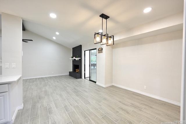 5914 Pineway, San Antonio, TX 78247 - unfurnished living room with recessed lighting, light wood-style flooring, baseboards, vaulted ceiling, and a brick fireplace