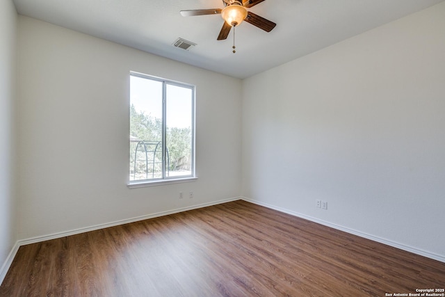 spare room featuring wood finished floors, ceiling fan, and baseboards
