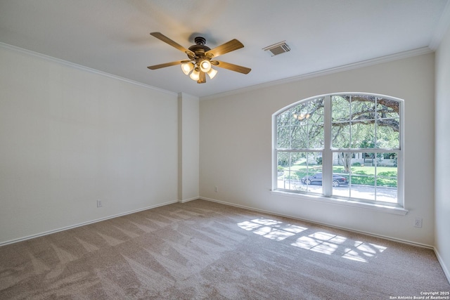 empty room with carpet flooring, a ceiling fan, ornamental molding, and baseboards