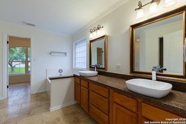 bathroom featuring ornamental molding, double vanity, stone finish flooring, a garden tub, and baseboards