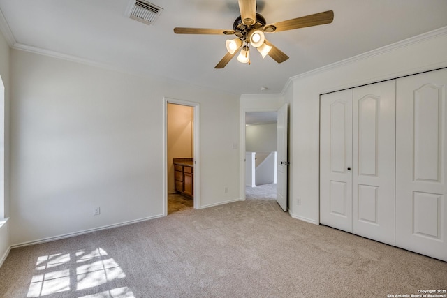 unfurnished bedroom with carpet floors, ornamental molding, a closet, baseboards, and ceiling fan
