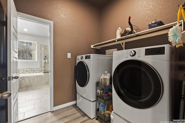 133 Edinburgh, Boerne, TX 78015 - laundry area with light wood-style flooring, independent washer and dryer, a textured wall, and baseboards
