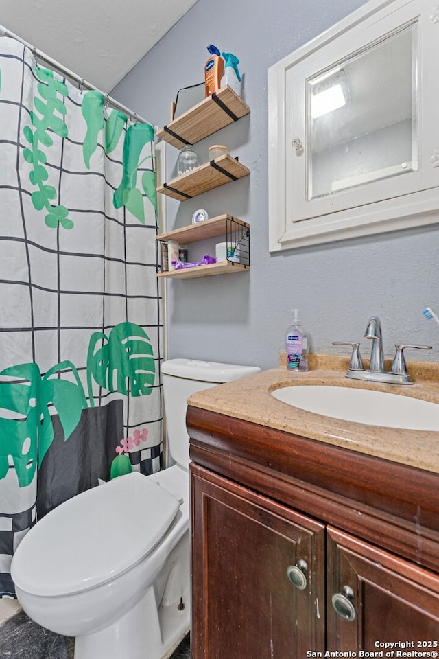 full bathroom featuring toilet, vanity, and curtained shower