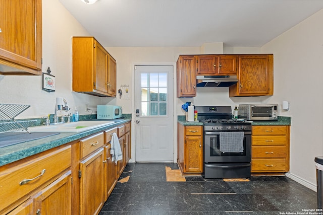 kitchen with stainless steel range with gas stovetop, under cabinet range hood, brown cabinetry, white microwave, and a sink