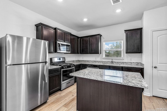 10825 Quinn Ct, San Antonio, TX 78252 - kitchen featuring stainless steel appliances, a sink, light stone countertops, light wood-style floors, and recessed lighting