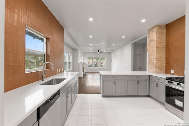1144 Denver, San Antonio, TX 78210 - kitchen featuring appliances with stainless steel finishes, gray cabinets, a sink, a peninsula, and light countertops