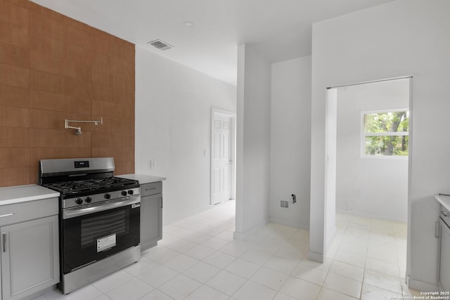 1144 Denver, San Antonio, TX 78210 - kitchen with stainless steel range with gas cooktop, light countertops, gray cabinets, and light tile patterned flooring