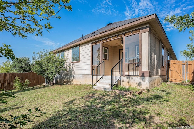 view of front of home featuring roof mounted solar panels, ceiling fan, and a gate