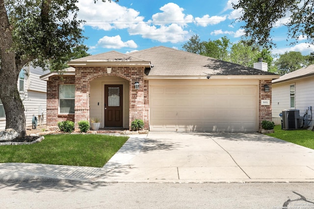 ranch-style home featuring brick siding, central AC unit, an attached garage, driveway, and a front yard