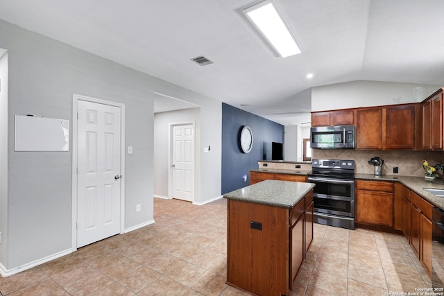 kitchen with stainless steel appliances, decorative backsplash, a kitchen island, vaulted ceiling, and light tile patterned floors