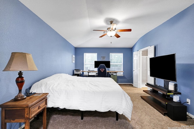 bedroom featuring lofted ceiling, carpet floors, baseboards, an office area, and a ceiling fan