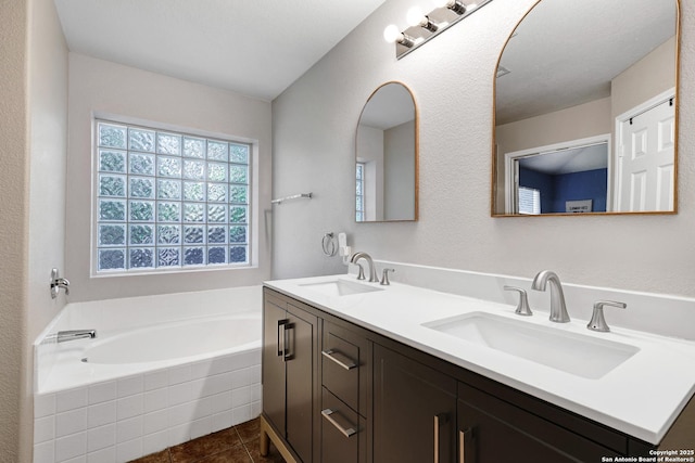 bathroom featuring a garden tub, tile patterned floors, and double vanity