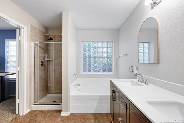 full bath with a shower stall, a garden tub, double vanity, and tile patterned flooring