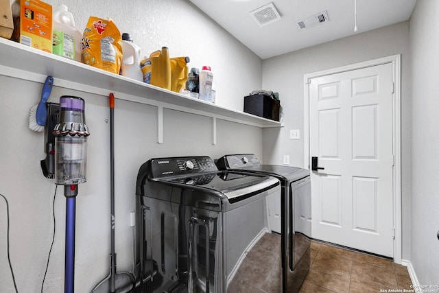 laundry room with washing machine and clothes dryer, tile patterned floors, and baseboards