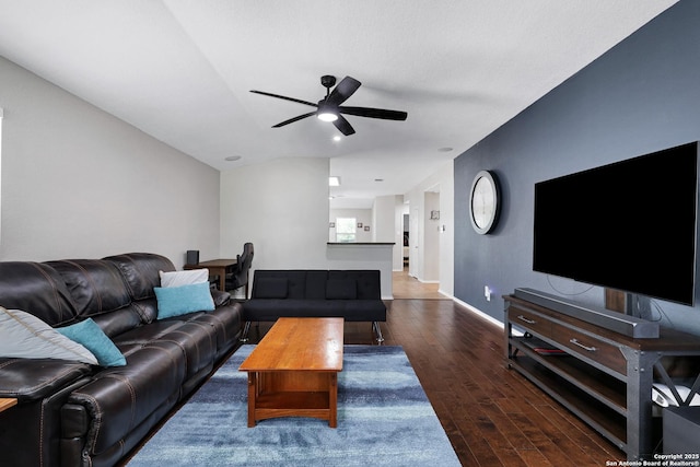 living area with wood finished floors, a ceiling fan, and baseboards