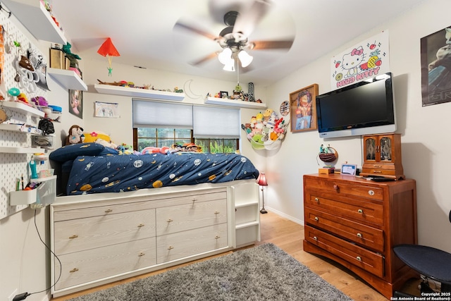 bedroom with light wood-type flooring, baseboards, and a ceiling fan