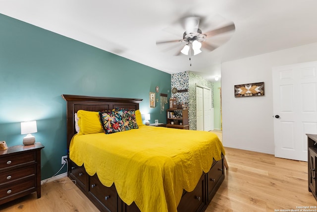 bedroom featuring light wood-style floors, a closet, baseboards, and ceiling fan