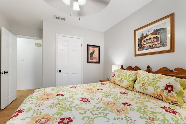 bedroom featuring light wood finished floors, a ceiling fan, and baseboards