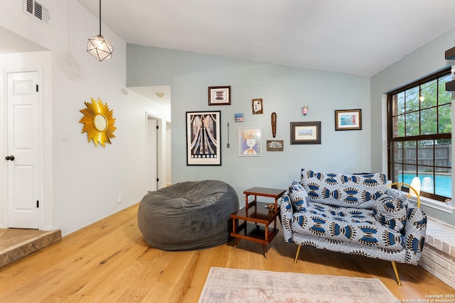 living area featuring lofted ceiling and wood finished floors
