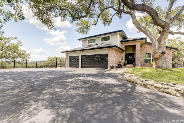 28426 Quadrille Ln, Boerne, TX 78015 - prairie-style house featuring fence, concrete driveway, an attached garage, and brick siding