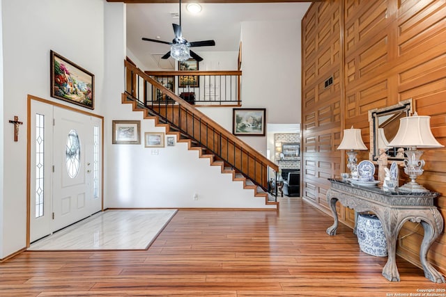 28426 Quadrille Ln, Boerne, TX 78015 - foyer with a towering ceiling, stairway, ceiling fan, a fireplace, and wood finished floors