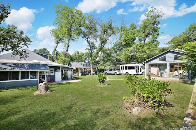 view of green lawn with a sunroom