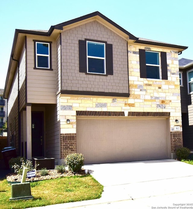 townhome / multi-family property with a garage, concrete driveway, and stone siding