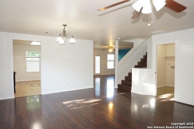 unfurnished living room featuring a ceiling fan, wood finished floors, stairway, and baseboards