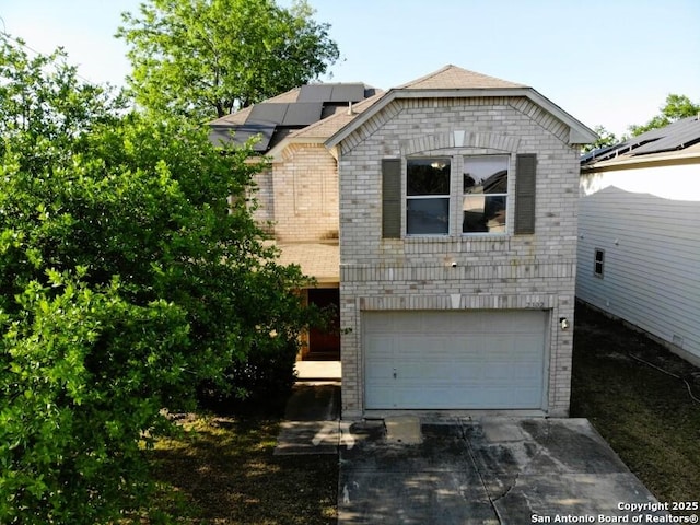 view of front of home with driveway, solar panels, an attached garage, and brick siding