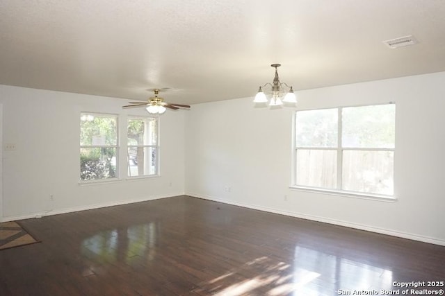 spare room featuring baseboards, dark wood-type flooring, a chandelier, and ceiling fan