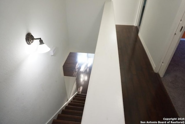 staircase with wood finished floors and baseboards