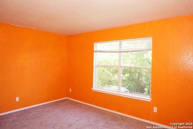 empty room with baseboards and carpet flooring